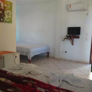 a room with two beds and a tv in it at Pousada Canoa Beach in Canoa Quebrada