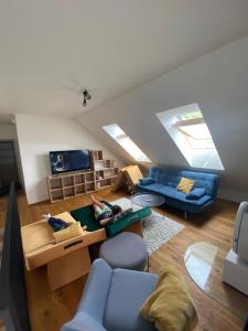 uma sala de estar com sofás azuis e uma televisão em Superb Mýto Apartment em Mýto pod Ďumbierom