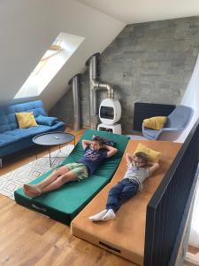duas crianças deitadas num sofá numa sala de estar em Superb Mýto Apartment em Mýto pod Ďumbierom