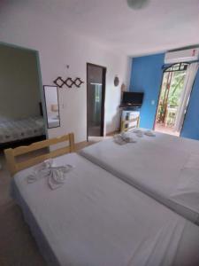 a bedroom with two beds and a window at Pousada Canoa Beach in Canoa Quebrada