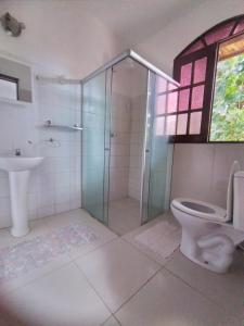 a bathroom with a shower and a toilet and a sink at Pousada Canoa Beach in Canoa Quebrada