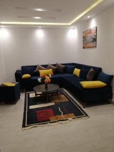 uma sala de estar com um sofá azul e uma mesa em Derby de Cité el Khadra em Tunes