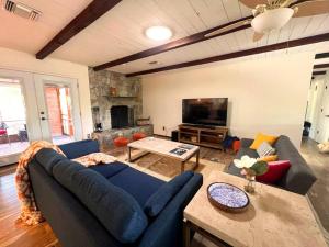 Una sala de estar con un sofá azul y un televisor en Casa Saguaro - Newly Remodeled, Pool and Mtn Views, en Tucson