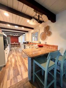 una cocina con una gran isla con sillas azules en Casa Saguaro - Newly Remodeled, Pool and Mtn Views, en Tucson
