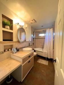Un baño con lavabo, inodoro y bañera. en Casa Saguaro - Newly Remodeled, Pool and Mtn Views, en Tucson