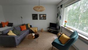 uma sala de estar com um sofá e cadeiras e uma janela em Aliisa's Apartment II em Rovaniemi