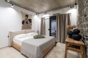 sypialnia z dużym łóżkiem i ceglaną ścianą w obiekcie Celine Private Residences w mieście Lentas