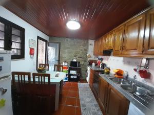 a kitchen with wooden cabinets and a table in it at Casa da Praça in Castelo Novo