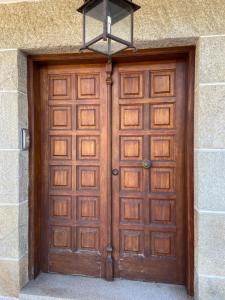 a wooden door on a building with a light above it at As Adegas in Poio