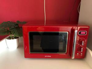 a red microwave sitting on a table with a plant at Апартамент 10 in Tsarevo