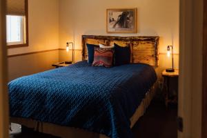 a bedroom with a blue bed with a wooden headboard at Sundance Motel in Pinedale