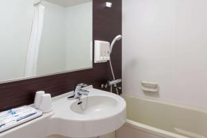 W łazience znajduje się biała umywalka i lustro. w obiekcie Comfort Hotel Tokyo Kanda w Tokio