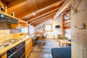 a kitchen with wooden ceilings and a living room at Chasa Allegra in Ftan