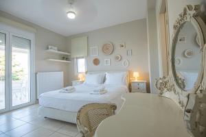 ミラトスにあるVilla Elenaの白いベッドルーム(大型ベッド1台、鏡付)