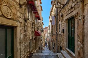 an alley in an old town with people walking down it at Old Town Casa Nevia- Deluxe Holiday Home in Dubrovnik with Stunning Views in Dubrovnik