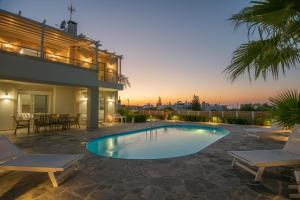 a backyard with a swimming pool and a house at Villa Elena in Milatos