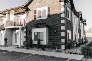 a brown brick house with white doors and windows at Beautiful New 3 BR 2BA Townhome No stairs in Logan