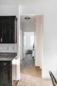 a hallway of a white room with a kitchen with a counter at Beautiful New 3 BR 2BA Townhome No stairs in Logan