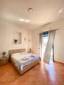 a bedroom with a bed and a large window at La casa di Nettuno in Naples