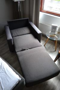 un sofá en una sala de estar con mesa y ordenador portátil en Comfortable hotel room at Ellivuori Resort, en Sastamala
