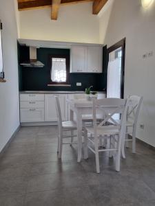 uma cozinha com uma mesa branca e cadeiras em Agriturismo Monte Oliveto em Palazzo