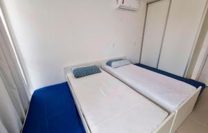 a small room with two beds in it at Areias do Mar 2 Quartos, Charmoso e Completo in Barra de São Miguel +17 photos