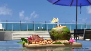 a table with a drink on top of a table at Areias do Mar 2 Quartos, Charmoso e Completo in Barra de São Miguel