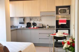 uma pequena cozinha com armários brancos e um micro-ondas em Rentasuite Lyon em Santiago