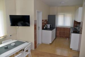 a small kitchen with a table and a tv on the wall at Affordable and Newly Renovated 1-bedroom Apartment in Kraljevo