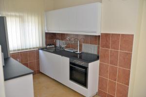 a kitchen with white appliances and brown tiles at Affordable and Newly Renovated 1-bedroom Apartment in Kraljevo