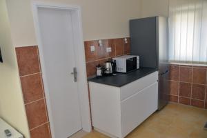 a small kitchen with a microwave and a refrigerator at Affordable and Newly Renovated 1-bedroom Apartment in Kraljevo