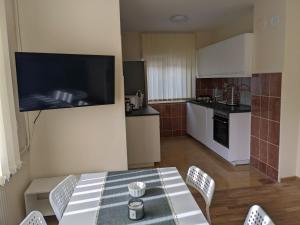a kitchen with a table and chairs and a television at Affordable and Newly Renovated 1-bedroom Apartment in Kraljevo