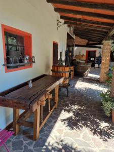 eine Terrasse mit einem Holztisch und Stühlen in einem Haus in der Unterkunft B&B Emma in Torreano