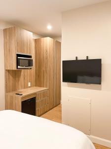 een hotelkamer met een bed en een televisie aan de muur bij Hotel Saint-Andre in Montreal