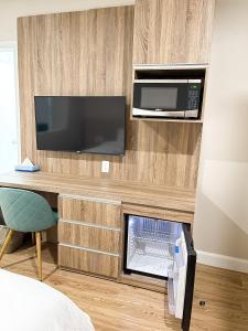 a hotel room with a microwave and a desk with a bed at Hotel Saint-Andre in Montreal