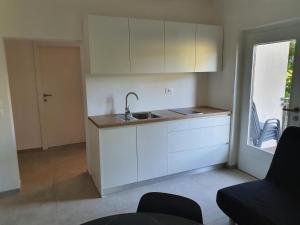 una cucina bianca con lavandino e finestra di Tisa Homes a Savudrija Altre 6 foto