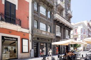 una calle con mesas y sombrillas en una calle de la ciudad en Il Palazzetto - Bari Sparano, en Bari