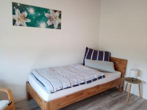 a bed in a room with a picture on the wall at Ferienwohnung Schwalbennest in Sommerach