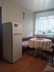 een keuken met een tafel en een witte koelkast bij Privat Ludmila in Liptovská Teplička