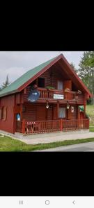 a large red cabin with a green roof at Guest house Anka in Žabljak