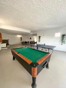 a ping pong table in a room with two tables at Villafavorita Casa Rural in Lorca