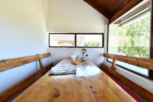 a wooden table in a room with two windows at Ivana in Saborsko