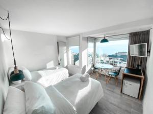a hotel room with two beds and a table with a view at Hotel Patagonia Signature in San Carlos de Bariloche