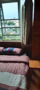 ein Schlafzimmer mit einem Bett neben einem Fenster in der Unterkunft Eco Home Da Lat in Da Lat