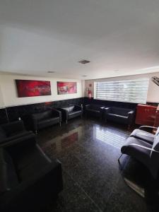 una sala d'attesa con divani neri e una finestra di For Lovers Jabaquara a San Paolo