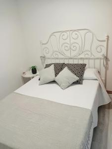 een slaapkamer met een wit bed met kussens erop bij Apartamento Ría Navia in Navia