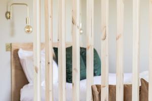 a white crib with a green pillow in a bedroom at Off the Track Getaway, Luxury Lodge in Crail