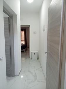 un corridoio con pavimenti in marmo bianco e porta di Ettore Casa Vacanze a Comiso