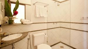 a white bathroom with a toilet and a sink at Solar do Carmo Suites & Apartments in Salvador