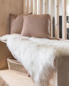 une fausse couverture en fourrure blanche assise sur un canapé dans l'établissement Off the Track Getaway, Luxury Lodge, à Crail